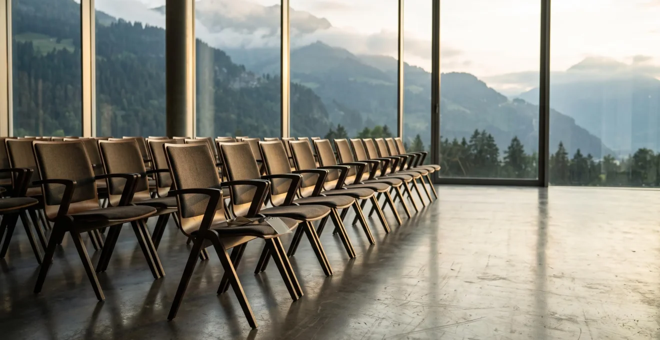 Salle de congrès suisse vide en fin de journée, symbole des opportunités professionnelles à saisir après l'événement