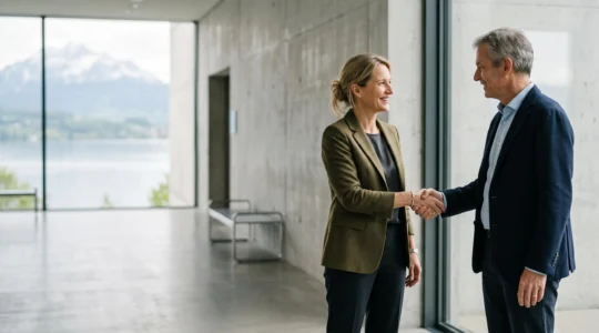 Deux professionnels du secteur culturel suisse scellent une collaboration par une poignee de main sincere dans un espace museal epure
